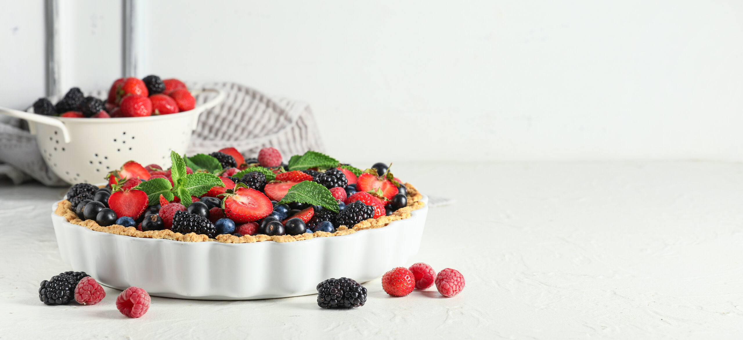Sweet tart with different fresh berries on white background. Banner for design
